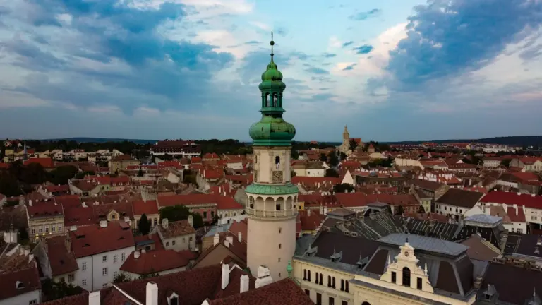 Luftaufnahme des historischen Kirchturms von Sopron bei malerischer Abendstimmung.