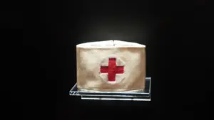 Historische Armbinde mit rotem Kreuz auf weißem Grund als Symbol der Genfer Konventionen.