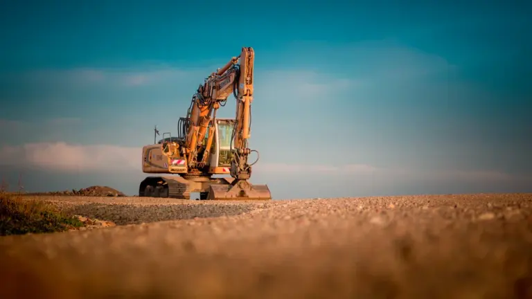 Ein gelber Bagger arbeitet auf einer Baustelle in Deutschland bei Tageslicht.