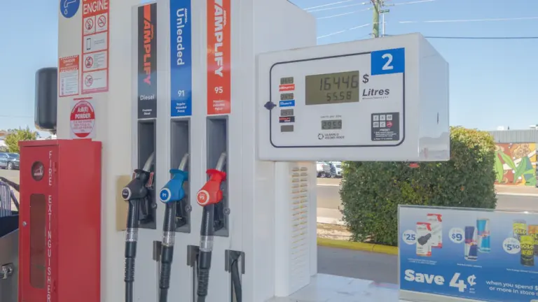 Moderne Zapfsäule mit digitaler Anzeige und verschiedenen Zapfpistolen an einer Tankstelle.