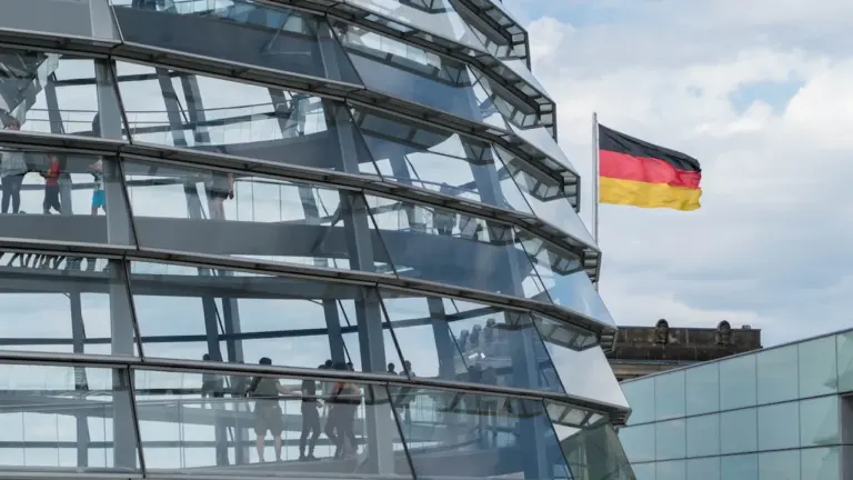 Die gläserne Kuppel des Reichstagsgebäudes in Berlin mit der deutschen Flagge.