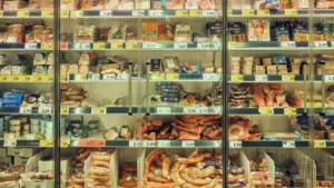 Kühlregal in einem deutschen Supermarkt gefüllt mit verschiedenen verpackten Lebensmitteln und Waren.