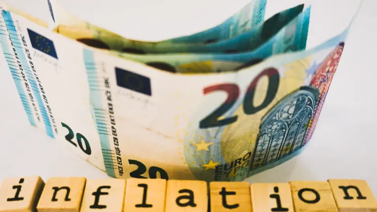 Ein 20-Euro-Schein liegt hinter Holzbuchstaben, die das Wort Inflation in Deutschland bilden.
