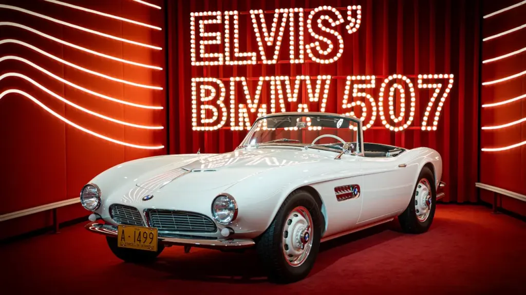 Der legendäre weiße BMW 507 von Elvis Presley auf einer roten Ausstellungsplattform.