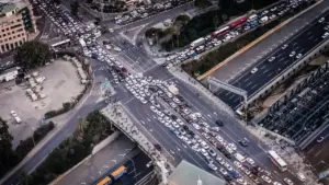 Luftaufnahme eines dichten Staus auf einer großen Autobahnkreuzung bei Tageslicht.