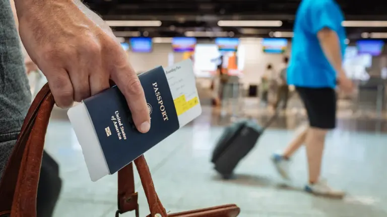Reisender am Flughafen hält einen Reisepass und ein Flugticket bereit.