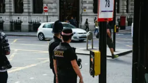Polizeibeamte der City of London Police stehen an einer belebten Straßenkreuzung in London.