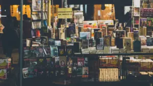Bücherregale voller unterschiedlicher Taschenbücher und Romane in einer Buchhandlung oder bei einem Verkauf.