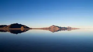 Spiegelbild eines Berges in einer ruhigen Wasseroberfläche bei blauem Himmel