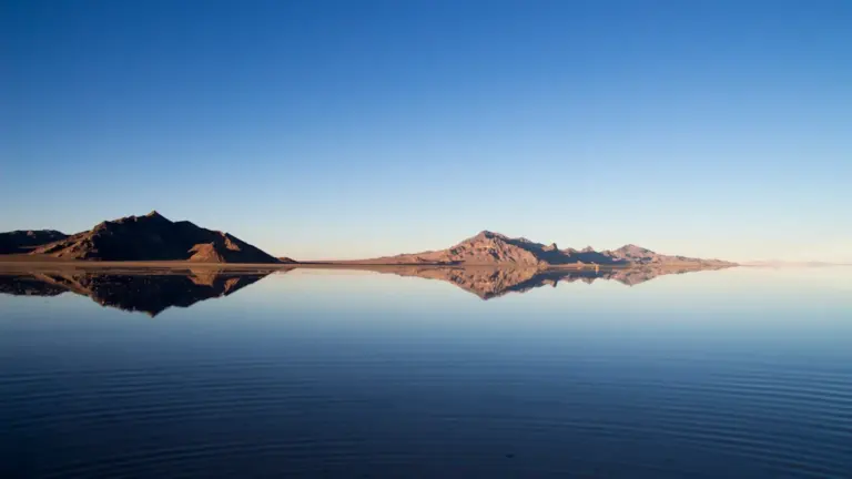 Spiegelbild eines Berges in einer ruhigen Wasseroberfläche bei blauem Himmel