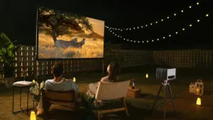 Paar genießt abends einen Film bei einem privaten Open-Air-Kino im Garten mit Lichterkette.