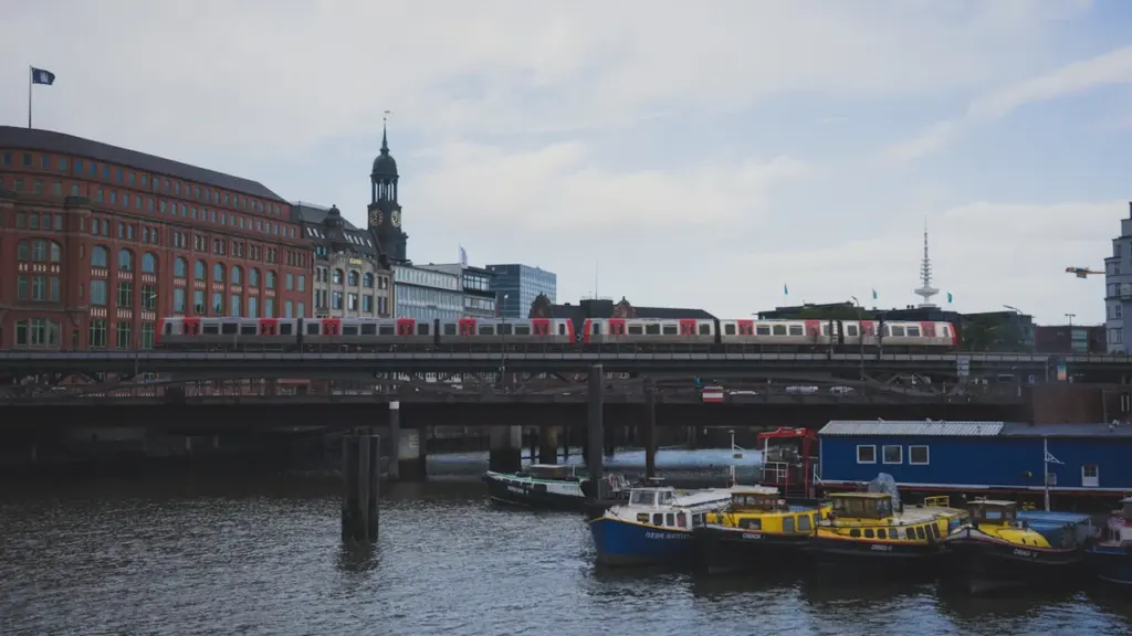 S-Bahn fährt über eine Hamburger Brücke, im Hintergrund die Stadtkulisse am Wasser.