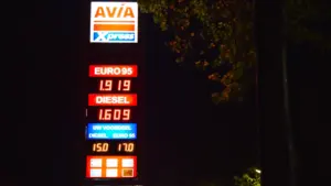 Digitales Preisschild einer Tankstelle in der Nacht mit Kraftstoffpreisen für Benzin und Diesel.