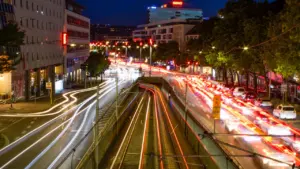 Lichtspuren von Autos an einer großen städtischen Kreuzung in Stuttgart bei Nacht.