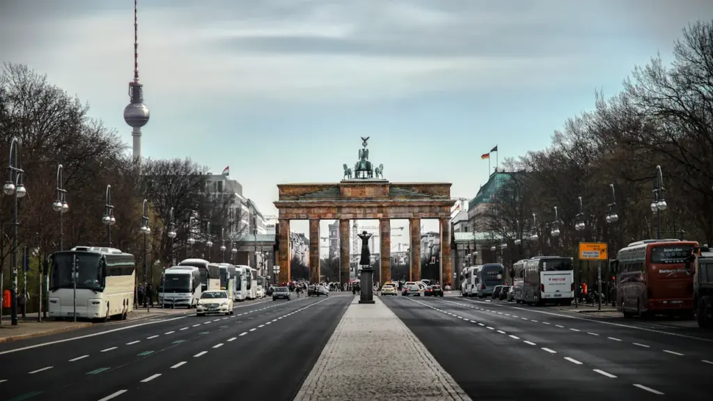 Das Brandenburger Tor und der Berliner Fernsehturm unter einem weiten, bewölkten Berliner Himmel.