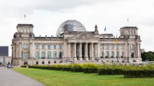 Das Berliner Reichstagsgebäude mit der Glaskuppel unter einem bewölkten Himmel in Berlin.