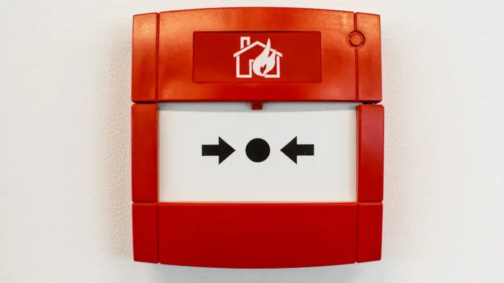 Ein roter Brandmelder an einer weißen Wand zur Sicherheit im Haushalt.