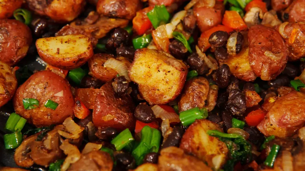 Eine herzhafte Pfannenmahlzeit mit knusprigen Kartoffeln und aromatischen Pilzen in einer Pfanne.