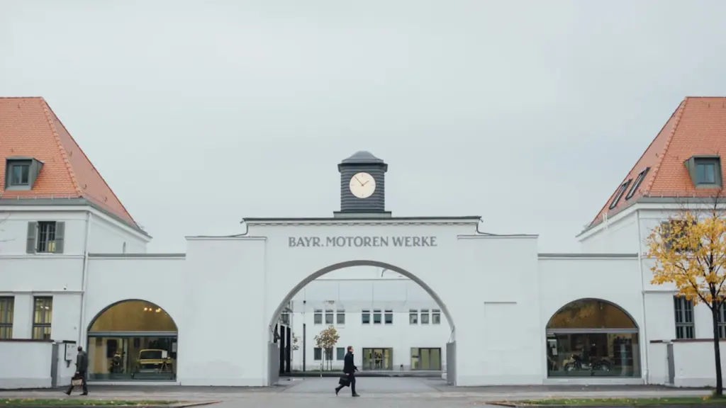 Das historische Verwaltungsgebäude der Bayerischen Motorenwerke mit einem Torbogen und einer zentralen Uhr.