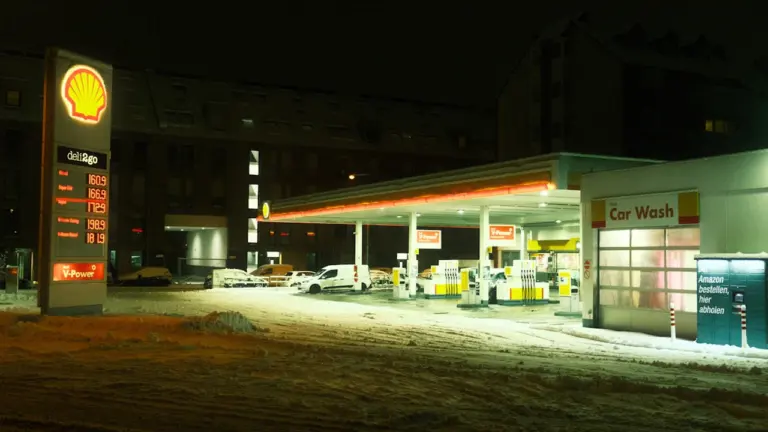 Eine beleuchtete Shell-Tankstelle bei Nacht zeigt die aktuellen Spritpreise auf der Anzeigetafel.