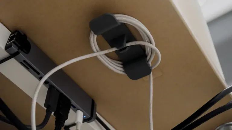 Ein Kabelhalter unter einem Schreibtisch hilft dabei, Ordnung im digitalen Alltag zu schaffen.