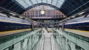Ein Bahnhof mit Zügen und einer großen Uhr über dem Gleisbereich.